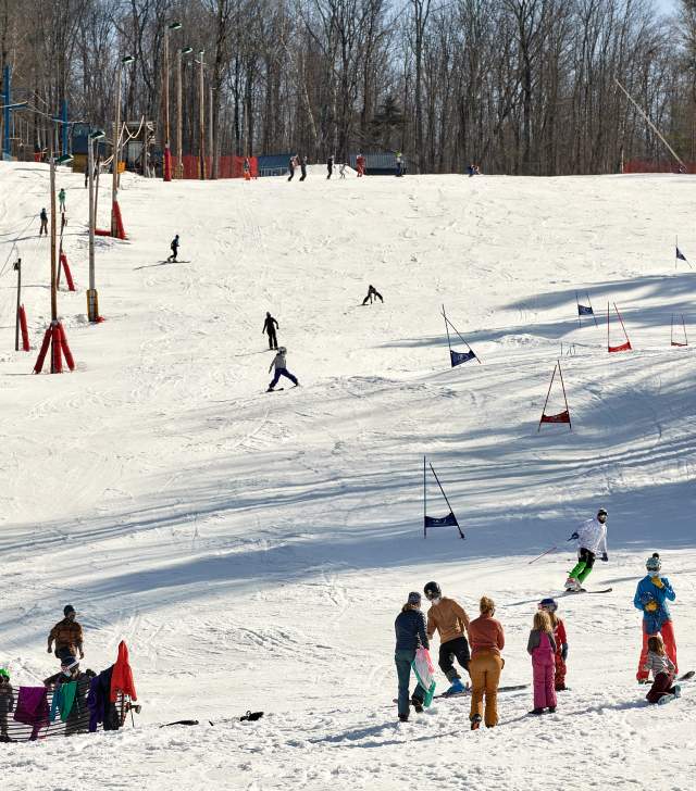Kid's ski race on hill covered in snow in winter