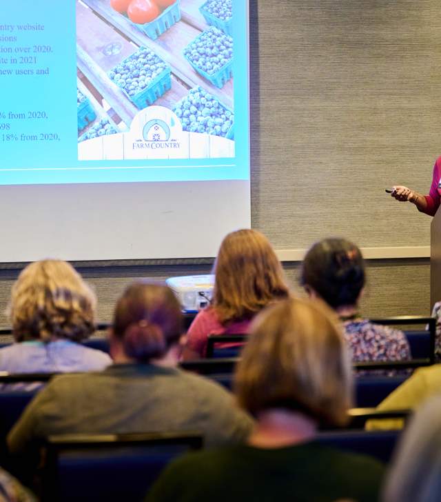 This is an image of a women presenting at a conference held at the Hilton Burlington in Burlington, VT