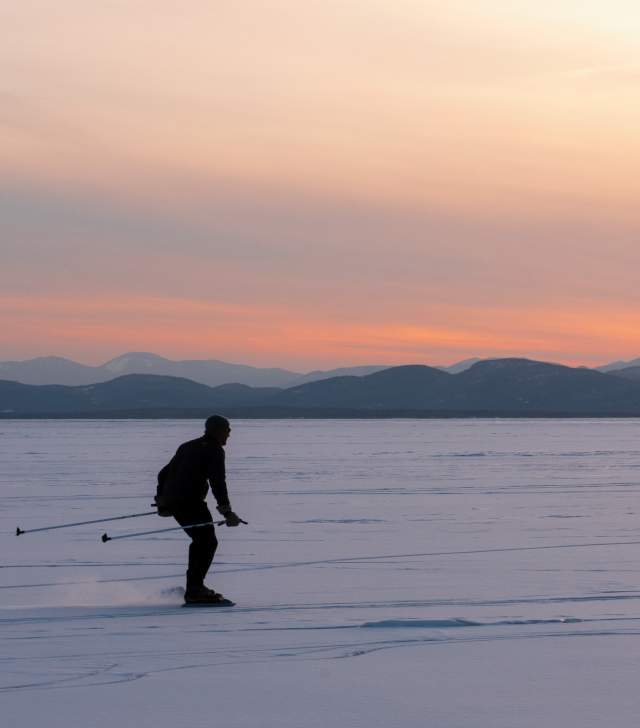 skier on the frozen lake at sunrise