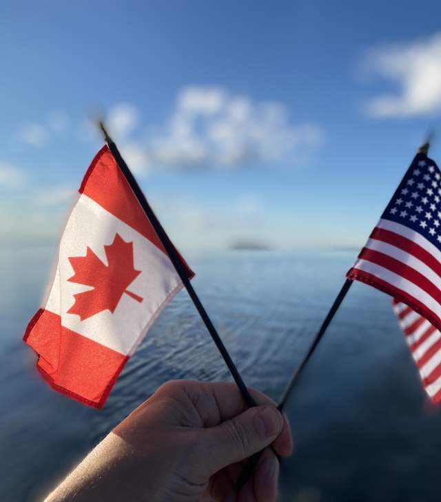 Canadian and United States Flags against Lake Champlain background