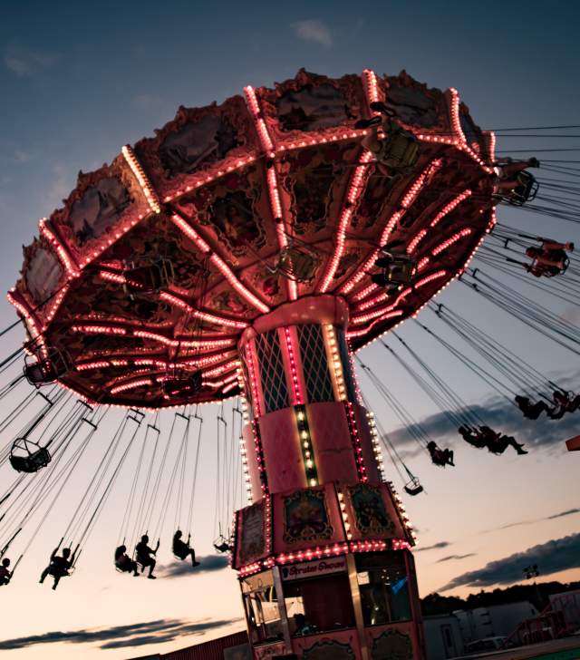 Swinging carousel with a sunset in the background and happy children laughing