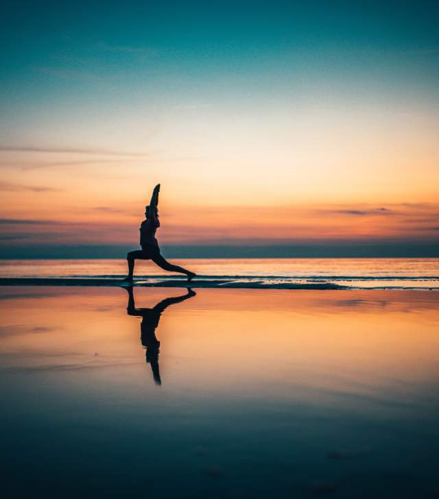 yoga at sunset on beach of Lake Champlain