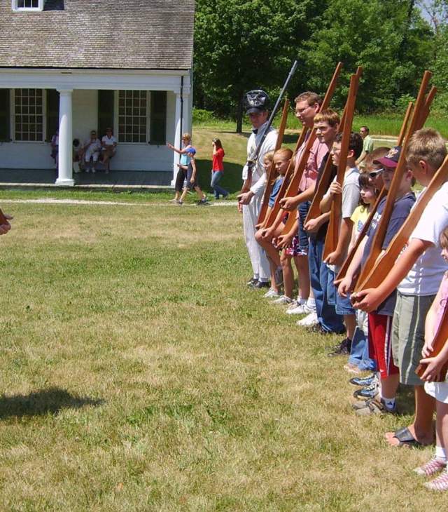 Man in civil-war era dress presenting to a group of tourists in a line