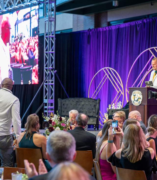 A man stands to be recognized at the 2022 Green and Gold Gala at Lambeau Field