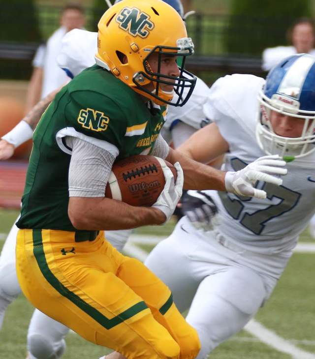 St. Norbert College football player carrying the ball