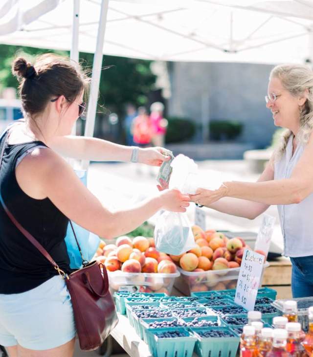 Woman purchasing fruit at farmers market