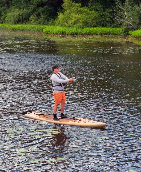 Man on paddleboard fishing in Huron River