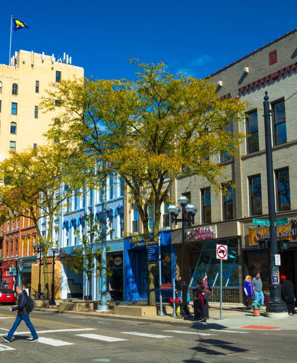Man crossing Main Street in downtown Ann Arbor