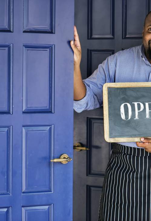 cheerful small business owner with open sign