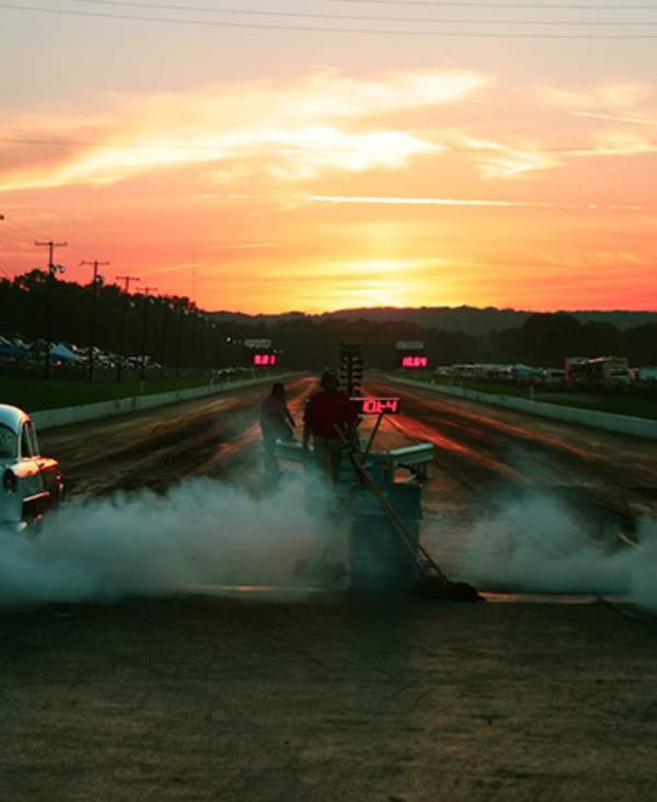 Vintage hot rods on the Beech Bend drag strip at sunset