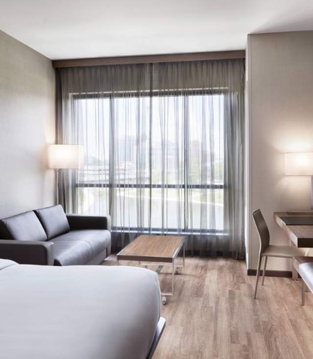 King Room at the AC Hotel. The room has a bed, leather couch, desk and stool.