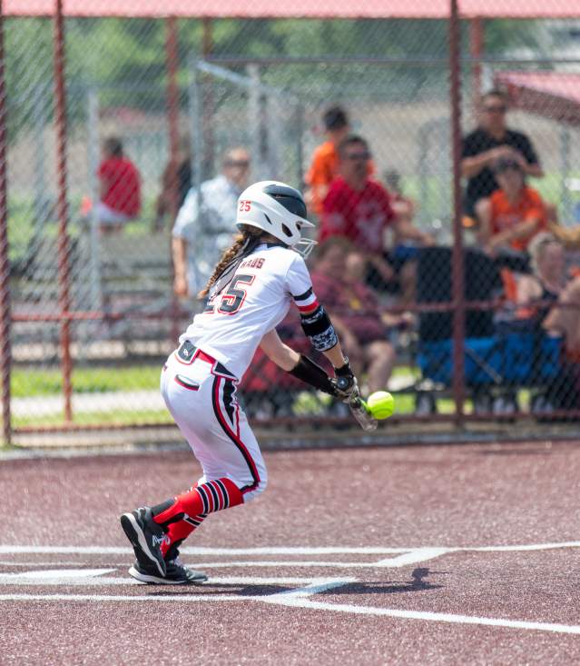 Image of a girl hitting a softball on a field