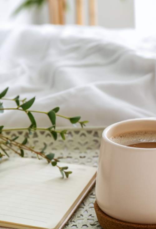 Coffee and journal on a bed