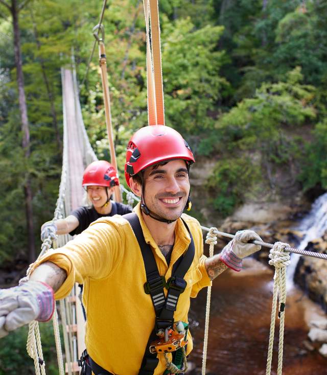 People crossing rope bridge