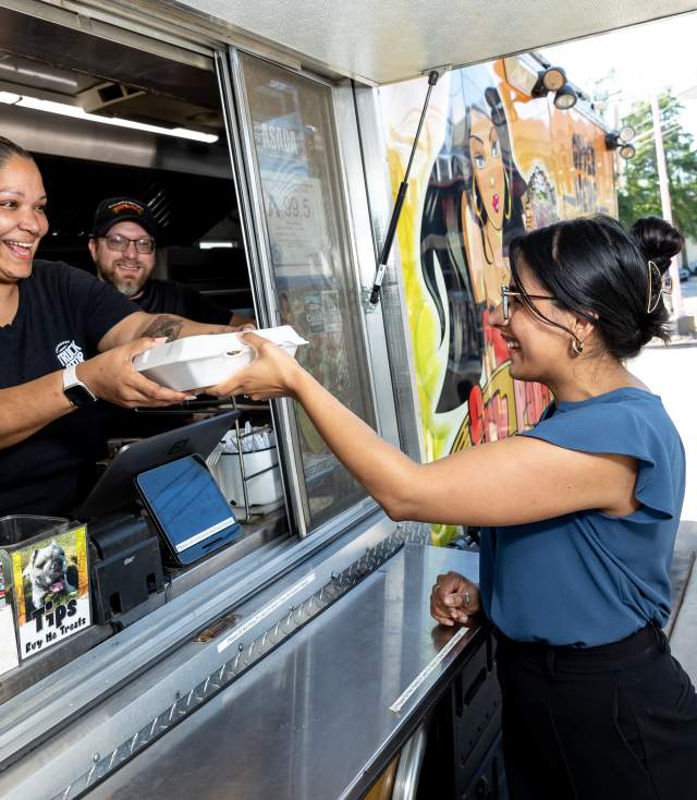A young woman receives her food from a Fayetteville, NC food truck