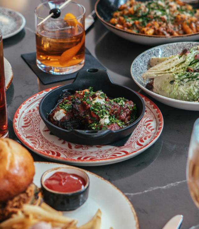 A table full of tasty dinner options from Amor&eacute; in downtown Fort Wayne. Setting includes drinks, salads, sandwhich, and pasta dishes.