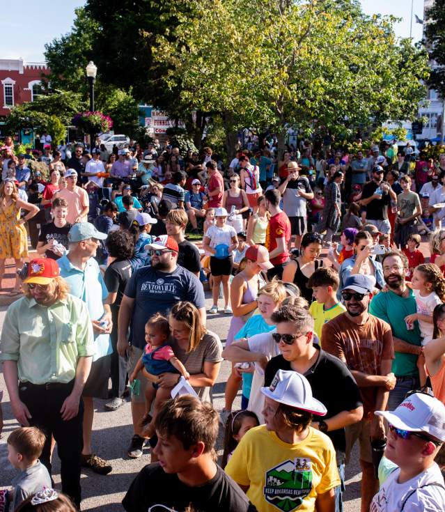 A vibrant crowd enjoying an outdoor summer event in Bentonville, showcasing the lively atmosphere of the season.