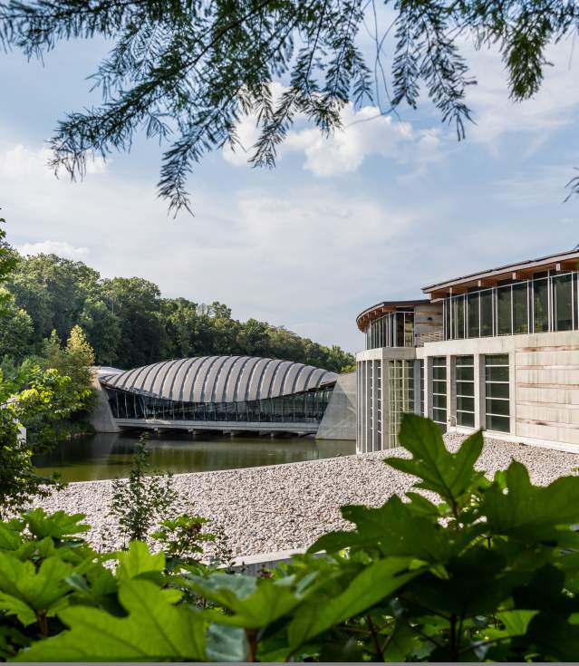 Crystal Bridges Museum of American Art with the edges of the image covered in green foliage.