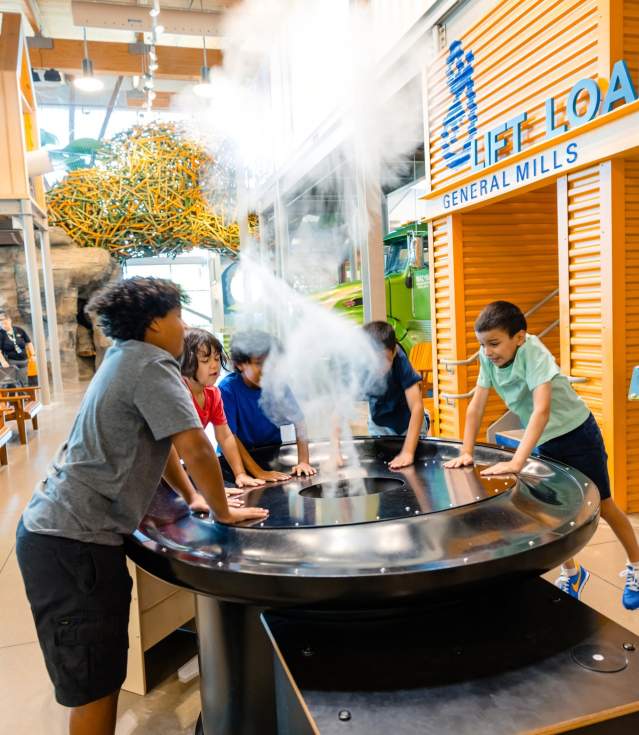 Kids experiment with a cloud making machine at Amazeum