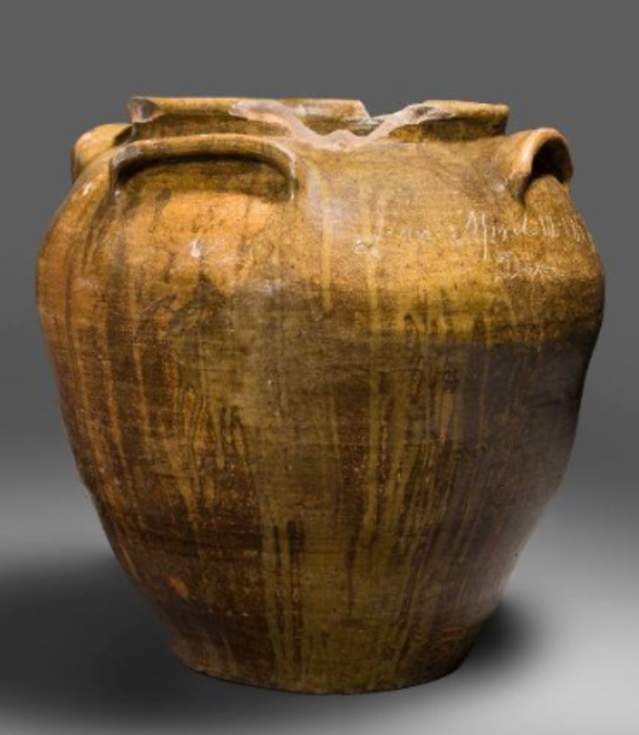A large, brown stoneware jar thrown circa 1858