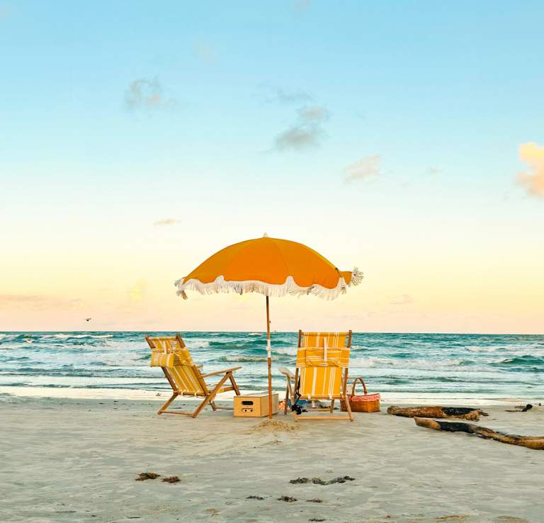 Beach with two yellow chairs and matching yellow umbrella