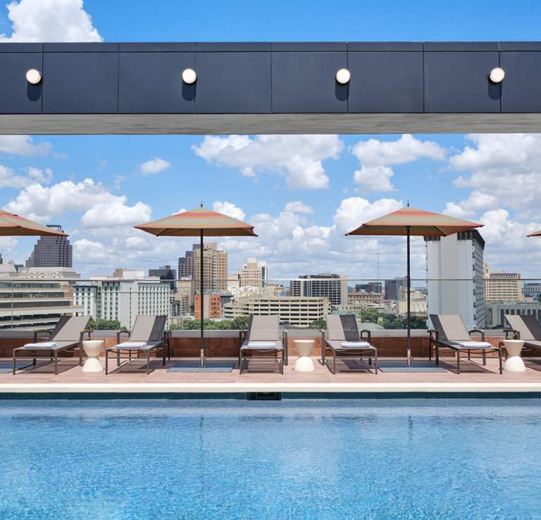 Hotel pool with lounge chairs and umbrellas