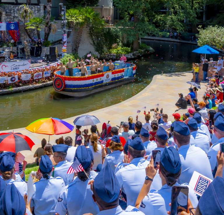 River barge floating along River Walk with Armed Forces in the audience