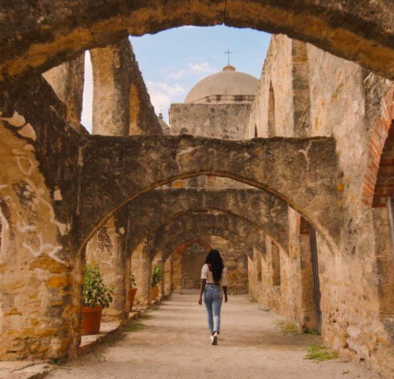 Woman walking through San Antonio Missions National Historial Park pathway