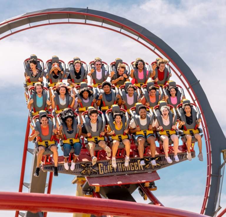 Roller coaster with three rows of people harnessed in