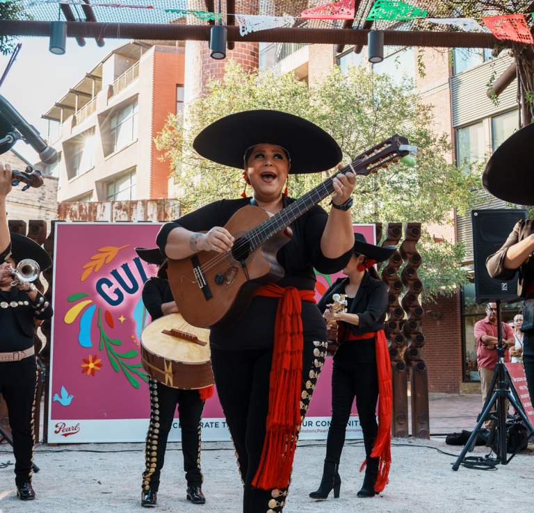 Mariachi players holding instruments and singing