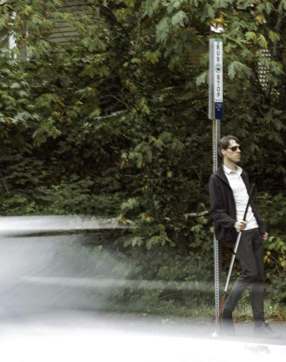 man waiting by a bus stop