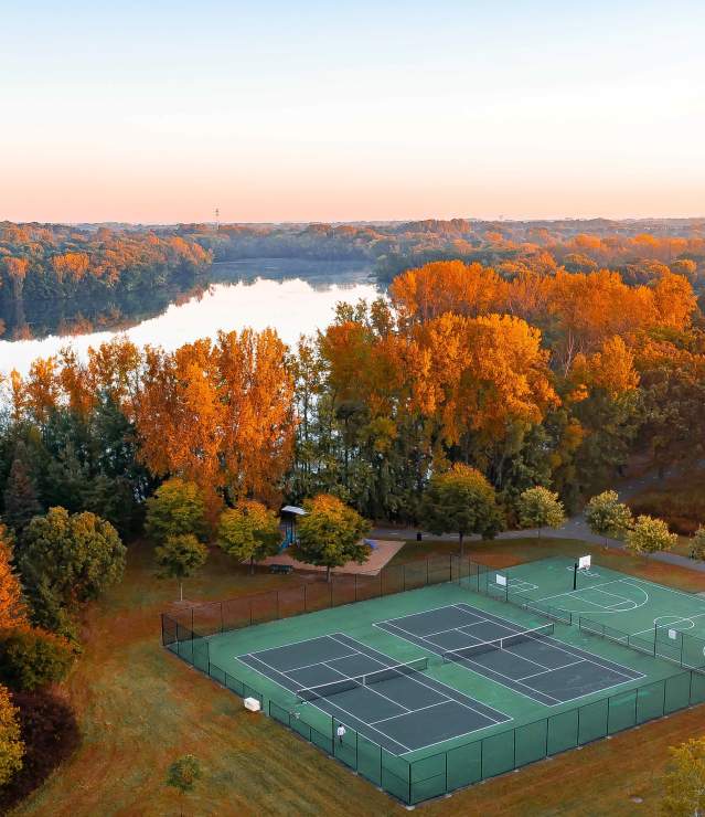 Edgewater Park aerial photo overlooking Colby Lake in the fall season with the foreground of the tennis and basketball courts
