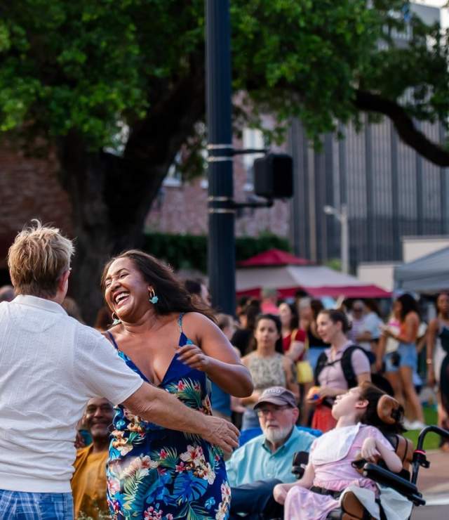 couple dancing in the street as a crowd of people watches in Downtown Lake Charles