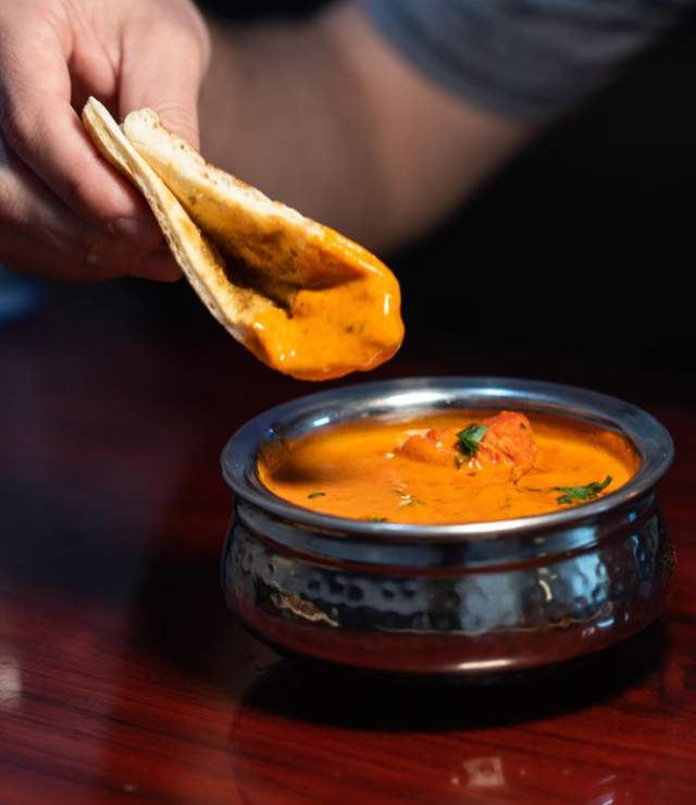 bread being dipped into orange soup