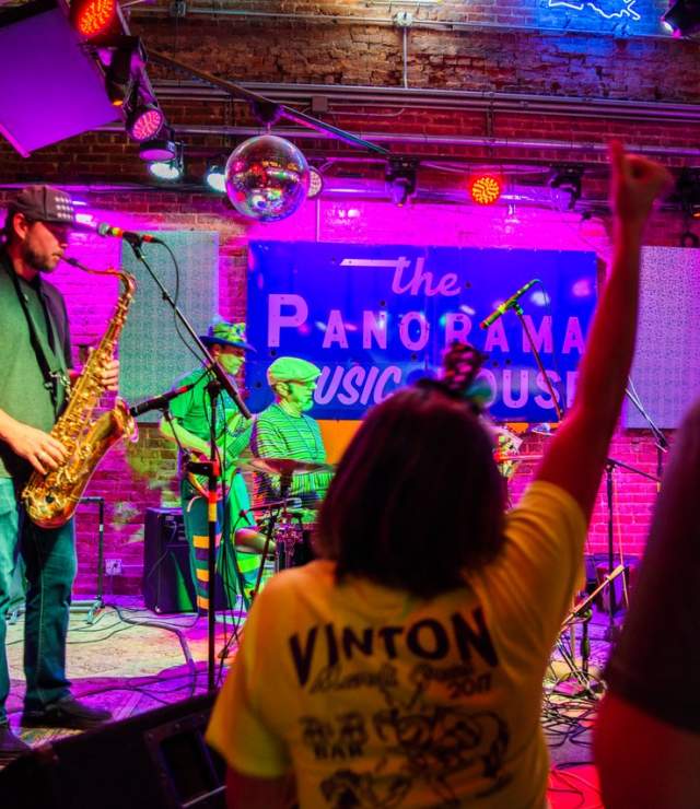 jazz musicians play onstage with saxophone, guitar, keyboard, and drums at panorama music house