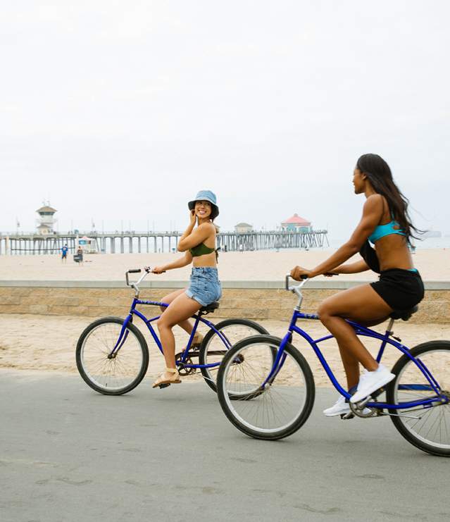Covid Updates in Huntington Beach. Image of biking on the boardwalk