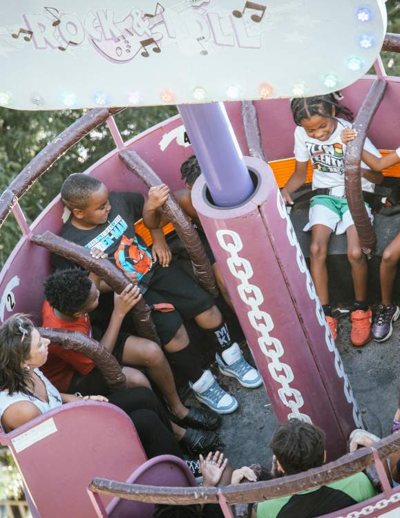 Kids riding one of the spinning rides at the Fun in the Park event for Juneteenth