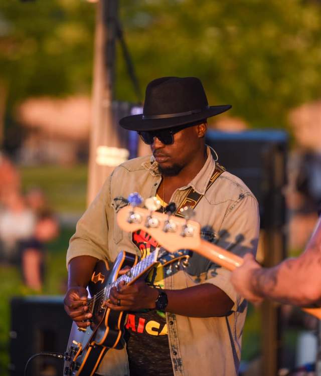 Musician playing guitar on outdoor stage