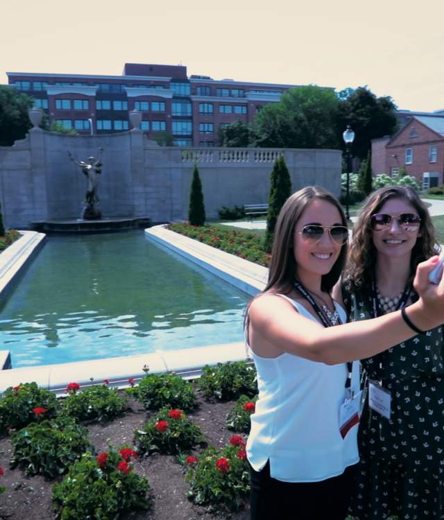 Two conference attendees taking a selfie in front of Spirit of Life in Saratoga Springs NY