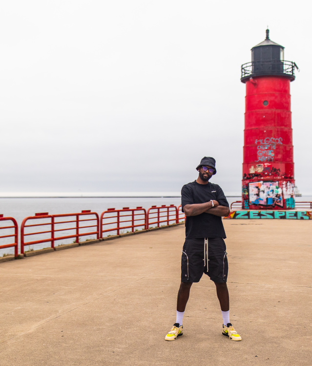 Bobby Portis posed in an all black outfit in front of a red lighthouse on Lake Michigan