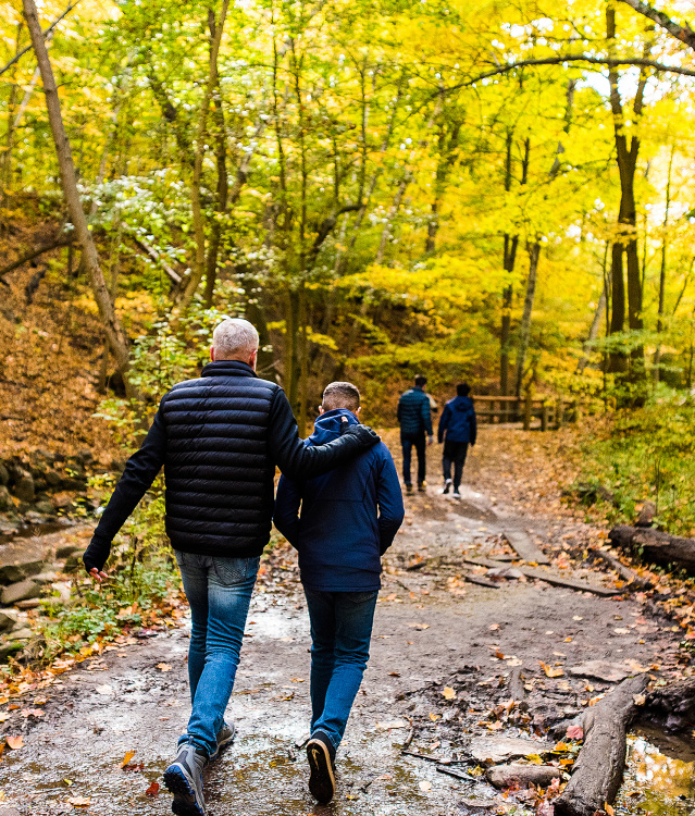 family walking on trail with fall colors surrounding