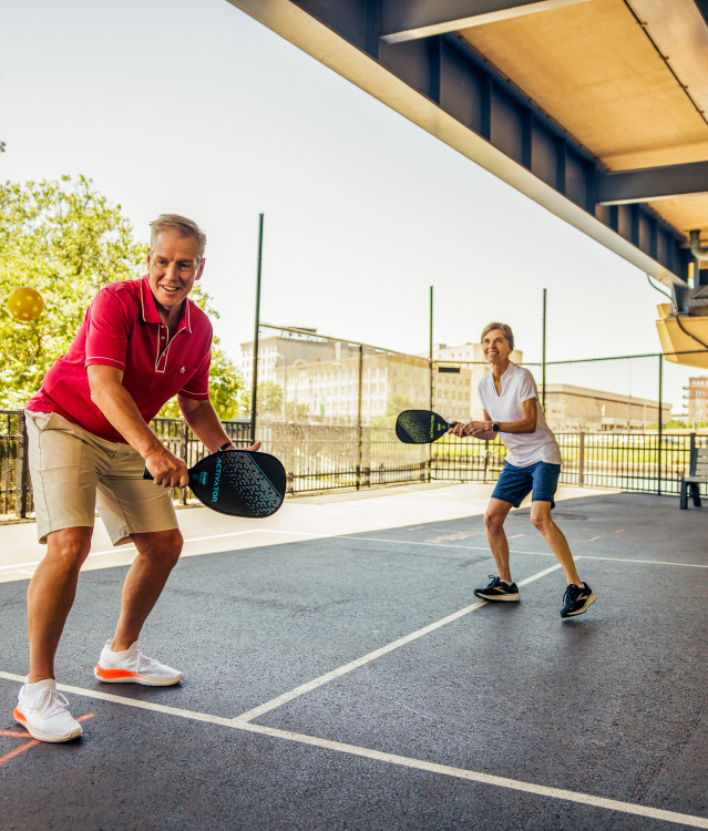 Couple playing pickleball at RiverWalk Commons