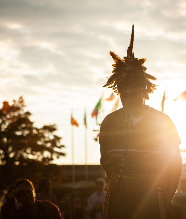 individual speaking into microphone with sunset behind