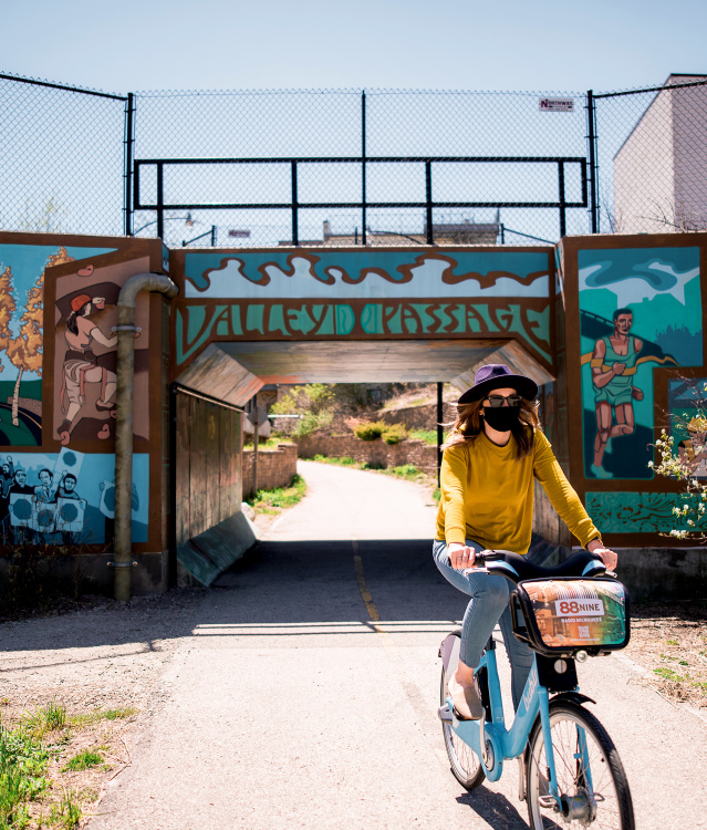 woman biking under Valley Passage Bridge