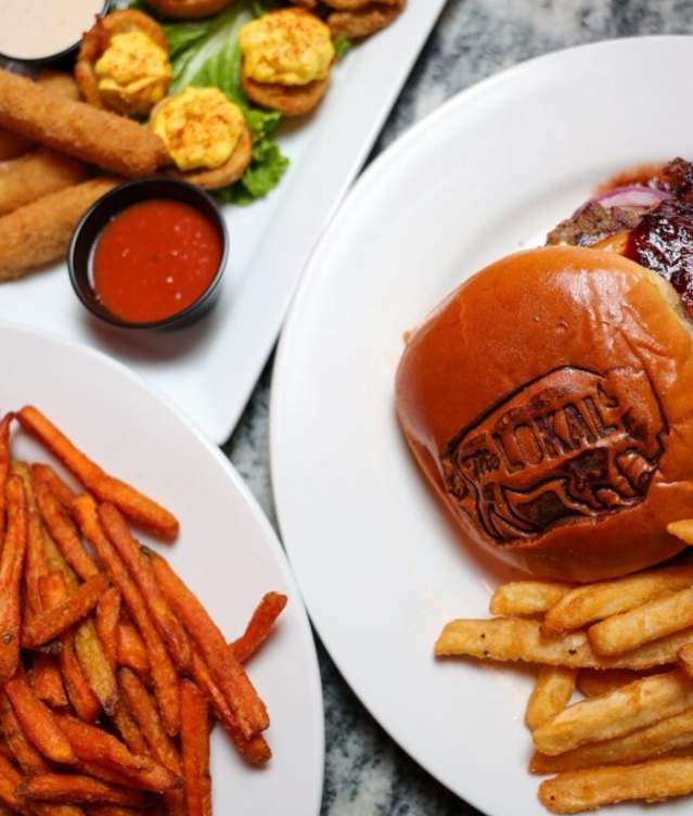 Overhead image of burgers, fries, and other eats from The Lokal in Norman, Oklahoma
