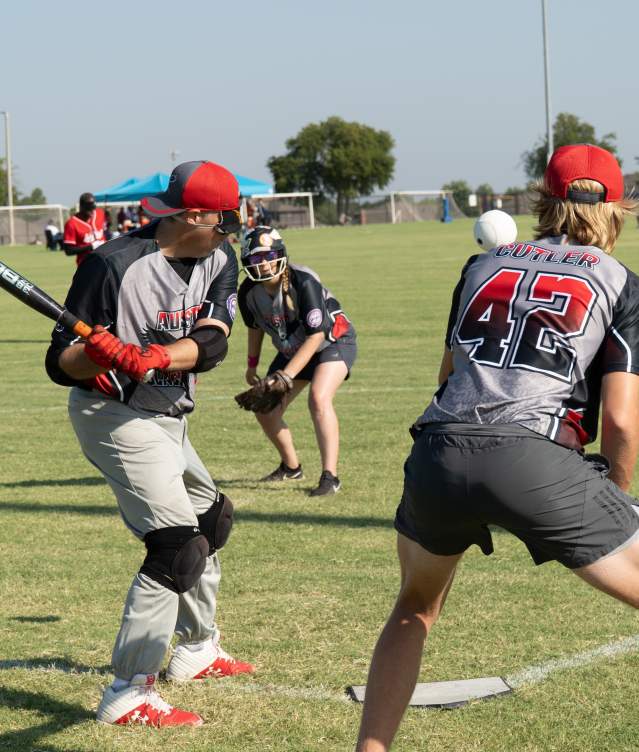 a few men on a baseball field hitting the ball