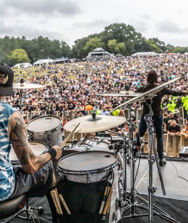 drummer and singer in front of large crowd