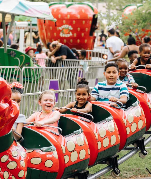 children enjoying a ride on a small roller coaster