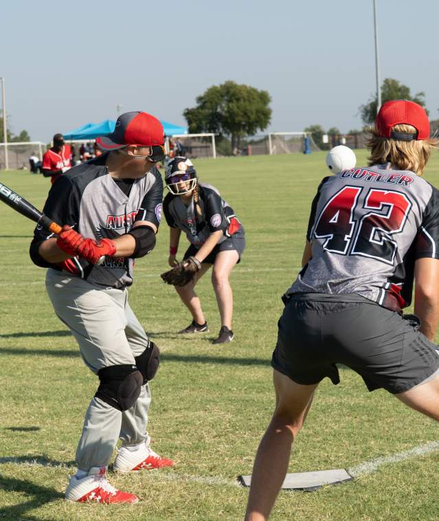 a few men on a baseball field hitting the ball