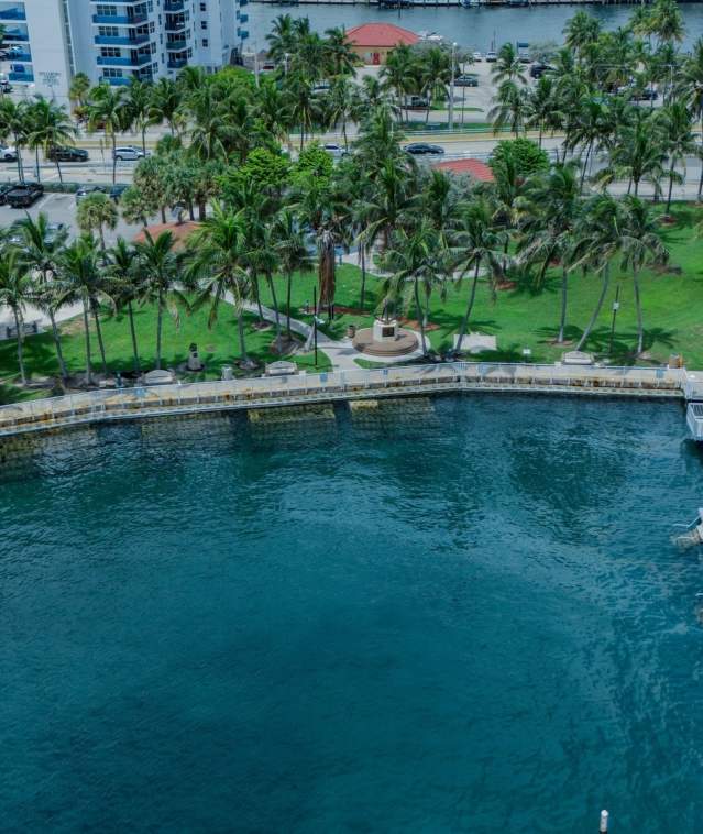 an aerial view of a picturesque bay with a dock in the Hillsboro Inlet in Pompano Beach, FL.